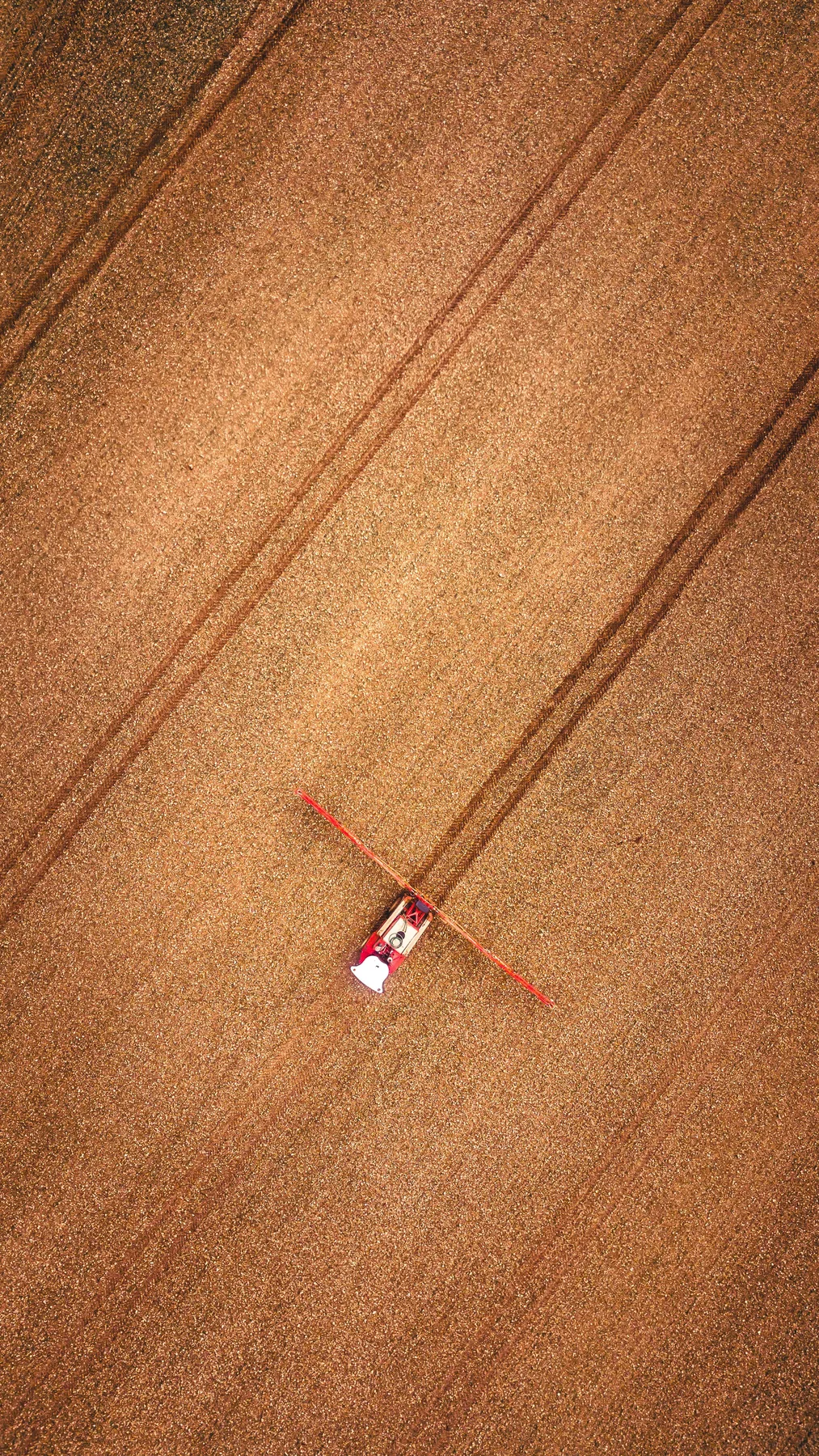Aerial view of a sprayer working a harvested field